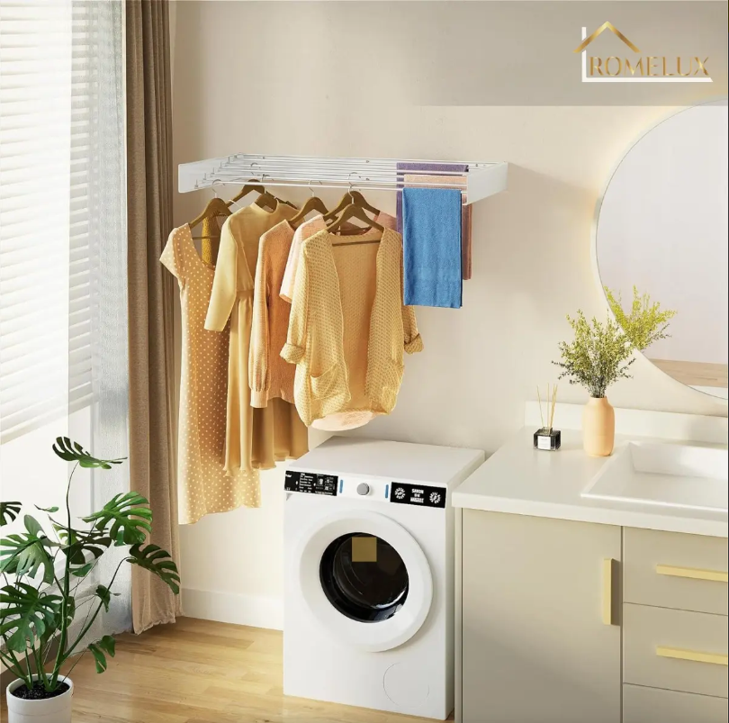 Laundry area with beige clothing on a wall-mounted rack above a front-loading washing machine, blue towel nearby.